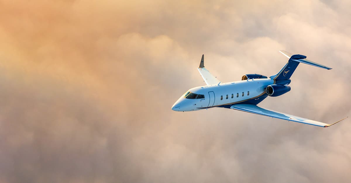 Airshare Challenger 3500 in flight over golden sun kissed clouds